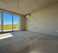 Prostorný pokoj v rodinném domě s velkými okny a výhledem do zahrady.