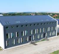 Budova na Levické ulici ve Vráblech s kancelářemi, moderní architektura a zelené okolí.