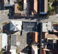 Letecký pohled na pozemky - bydlení v Nových Zámcích, obklopené budovami a silnicemi.