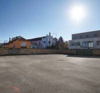 Pozemek v Nových Zámcích vhodný k bydlení, obklopený budovami a slunečným počasím.