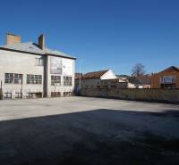 Exteriér budov a otevřená plocha ve městě Nové Zámky, vhodná pro Pozemky - bydlení.