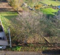 Pozemek na bydlení v Dolní Krupé na M.H. Chvotekové obklopený zelení a stromy.