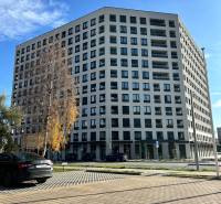 Bytový dům na Karpatské ulici v Popradu, okolní parkoviště a stromy.