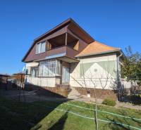 Rodinný dům ve Vráblech s podkrovím, menší terasou a zahradou s ovocnými stromy.