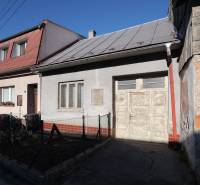 Rodinný dům na Kostelní ulici v Rajci s autem vpředu a dřevěným plotem.