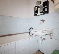 Koupelna s vanou, umyvadlem a modrými obklady v rodinném domě.