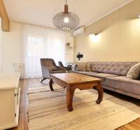 Obývací pokoj v 3-pokojovém bytě s podlahou s dřevěným dekorem a stylovým nábytkem.