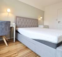 Ložnice v 3pokojovém bytě s komfortní postelí a podlahou s dřevěným dekorem.