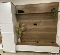 V 1-pokojovém bytě je šatníková stěna s dřevěným dekorem a květinami ve váze.