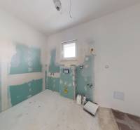 Nedokončená koupelna v rodinném domě s rozestavěným sanitárním zařízením.