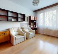 Kuchyně ve 3-pokojovém bytě s podlahou s dřevěným dekorem a sezením u okna.