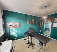 Pokoj v 3-pokojovém bytě s tyrkysovou stěnou, křeslem a dekoracemi.