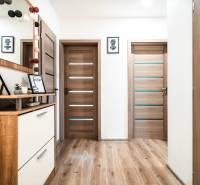 Interiér 2-pokojového bytu s podlahou s dřevěným dekorem, dveřmi a dekoracemi.