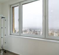 Balkon s výhledem v 2pokojovém bytě, sušák na prádlo, město v mlze.