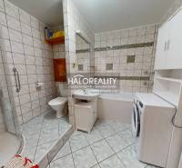 Koupelna v 2-pokojovém bytě s vanou, sprchovým koutem a pračkou.