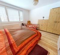 Ložnice v 2-pokojovém bytě s postelí, skříní a podlahou s dřevěným dekorem.