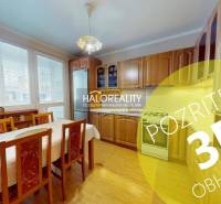 Kuchyně v 2pokojovém bytě se světlým dřevěným dekorem a jídelním stolem.