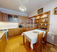 Kuchyně v 2pokojovém bytě s jídelním stolem a podlahou s dřevěným dekorem.