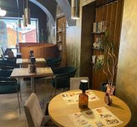 Interiér gastro prostorů s dřevěným dekorem a dekorací na stěnách.