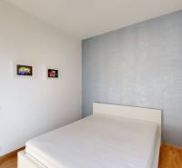 Ložnice se světlými stěnami, postelí a uměním na stěnách, 4pokojový byt.