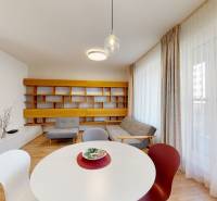 Obývací pokoj s podlahou s dřevěným dekorem, sedačkou a originální nástěnnou policí.