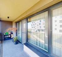 Balkon v Bratislavě - Lamači s výhledem, velkými okny a květinovou výzdobou.