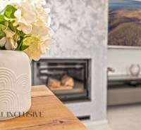 Váza s květinami na stole, podlaha s dřevěným dekorem, krb v rodinném domě.