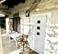 Rodinný dům v Jablonci se stolem a židlí na dvoře.