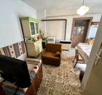 Obývací pokoj v rodinném domě s rustikálním nábytkem a vzorovanou podlahou.