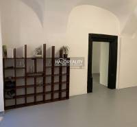 Interiér kanceláře s klenutými stropy a dřevěnou knihovnou.