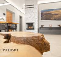 Obývací pokoj v rodinném domě s krbem, dekorativním dřevěným stolem a pohodlným sezením.