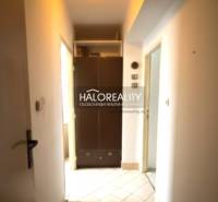 Chodba ve 3-pokojovém bytě s vestavěnou skříní a svítidlem na stropě.