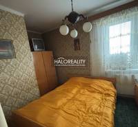 Ložnice v 3-pokojovém bytě s retro tapetou a televizorem.