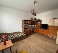 Obývací pokoj v 3-pokojovém bytě s podlahou s dřevěným dekorem, dřevěný nábytek, pohovka.