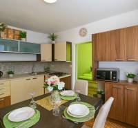 Kuchyně v 1-pokojovém bytě s jídelním stolem a podlahou s dřevěným dekorem.