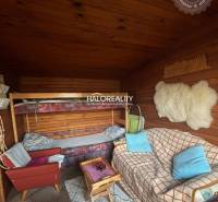 Pokoj s pohovkou, patrovou postelí a podlahou s dřevěným dekorem v zahradách.