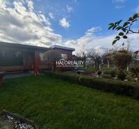 Dřevěný altán v zahradě ve Spišské Nové Vsi se zeleným trávníkem a zelení.