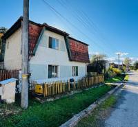 Rodinný dům v Brodzanech s dřevěným plotem a udržovanou zahradou u tiché ulice.