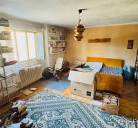 Knihovna a nábytek v pokoji rodinného domu s podlahou s dřevěným dekorem.