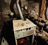 Kotelná v rodinném domě s měřicími přístroji a ocelovým komínem.