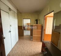 Chodba v 3-pokojovém bytě s dřevěnými a bílými prvky na stěnách.