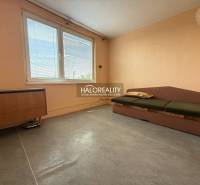 Světlý pokoj s pohovkou v 3-pokojovém bytě, dřevěný nábytek, velké okno.