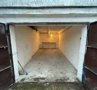 Otevřená garáž na Priekopách v Bratislavě - Ružinov, s betonovou podlahou a čelním stolem.