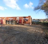 Stavba rodinného domu na Drieňové ulici v Nitře, rozestavěné cihlové stěny v přírodě.