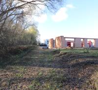 Rozestavěný rodinný dům na Drieňové ulici v Nitře obklopený stromy a přírodou.