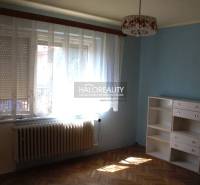 Pokoj v rodinném domě s podlahou s dřevěným dekorem, modrou stěnou a bílou skříní.