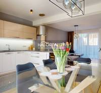 Kuchyně spojená s obývacím pokojem, skleněný stůl s květinami, rodinný dům, moderní osvětlení.