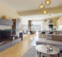 Obývací pokoj s podlahou s dřevěným dekorem, pohodlnou sedačkou a prostornou kuchyní v rodinném domě.