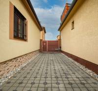 Dlázděný chodník mezi rodinnými domy na Školní ulici v Senci.