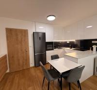 Kuchyně v 2-pokojovém bytě s podlahou s dřevěným dekorem a vestavěnými spotřebiči.